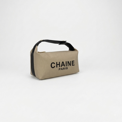 Beige canvas cosmetic pouch with black handle strap, gold clasp, CHAINe PARIS logo
