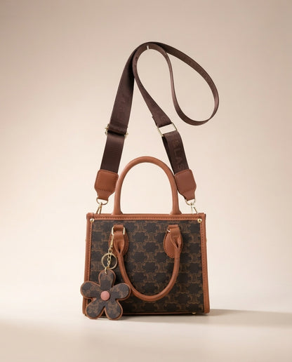 Brown patterned structured tote with tan shoulder strap and hanging flower charm