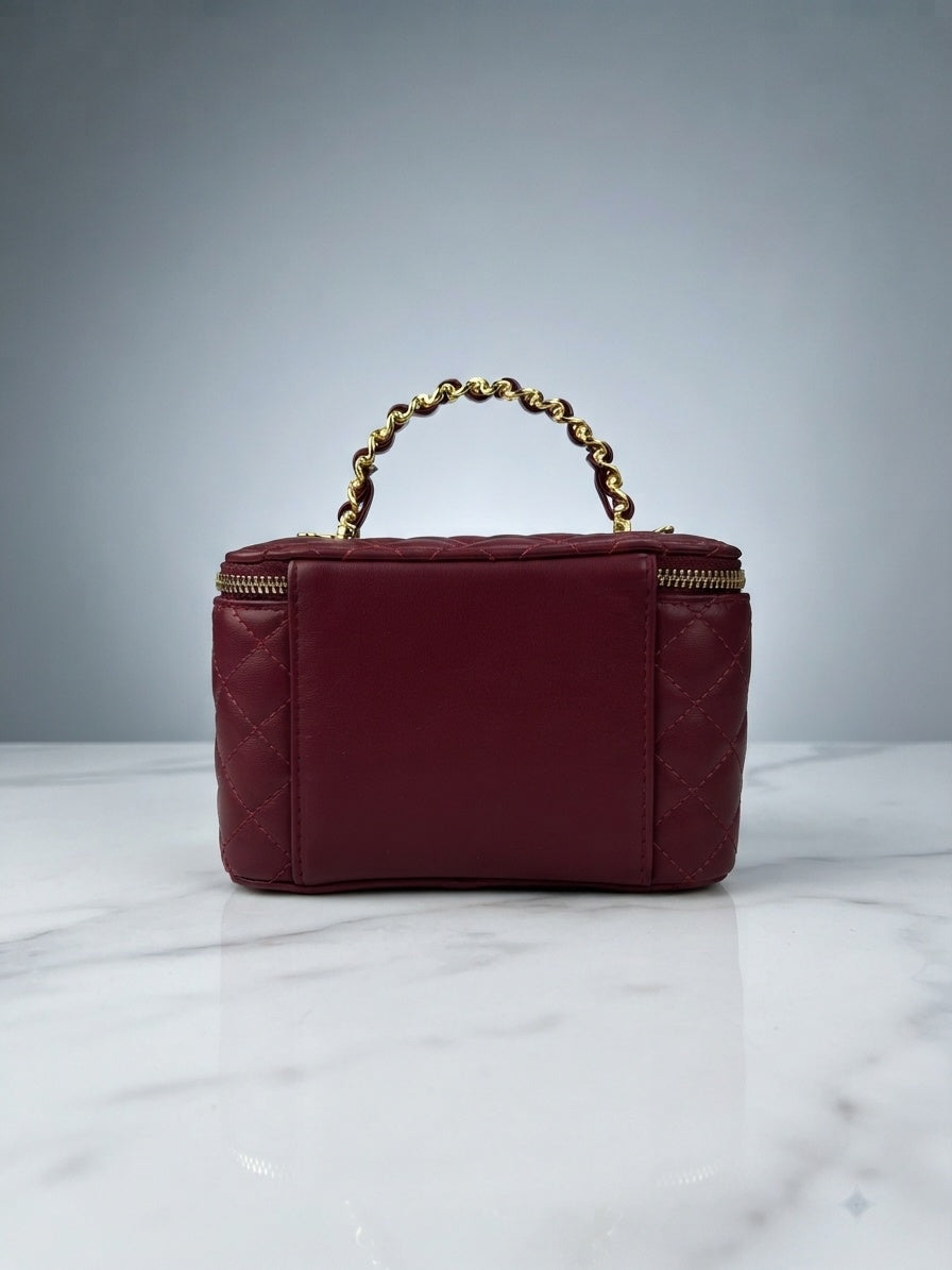 Maroon quilted vanity cosmetic case with chain handle and top zip enclosure