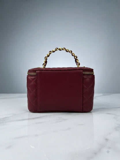 Maroon quilted vanity cosmetic case with chain handle and top zip enclosure