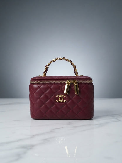 Maroon quilted vanity cosmetic case with chain handle, top zip, and interlocking CC logo