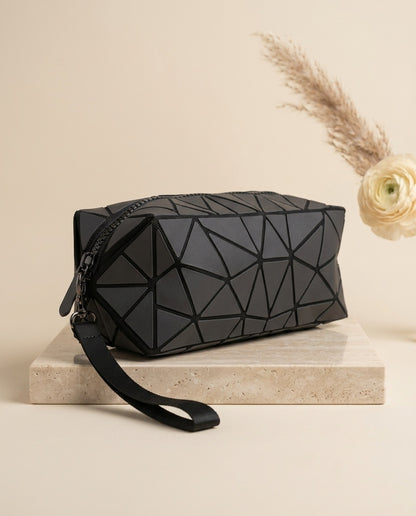 Black geometric cosmetic pouch with wristlet strap, zipper top, faceted pattern