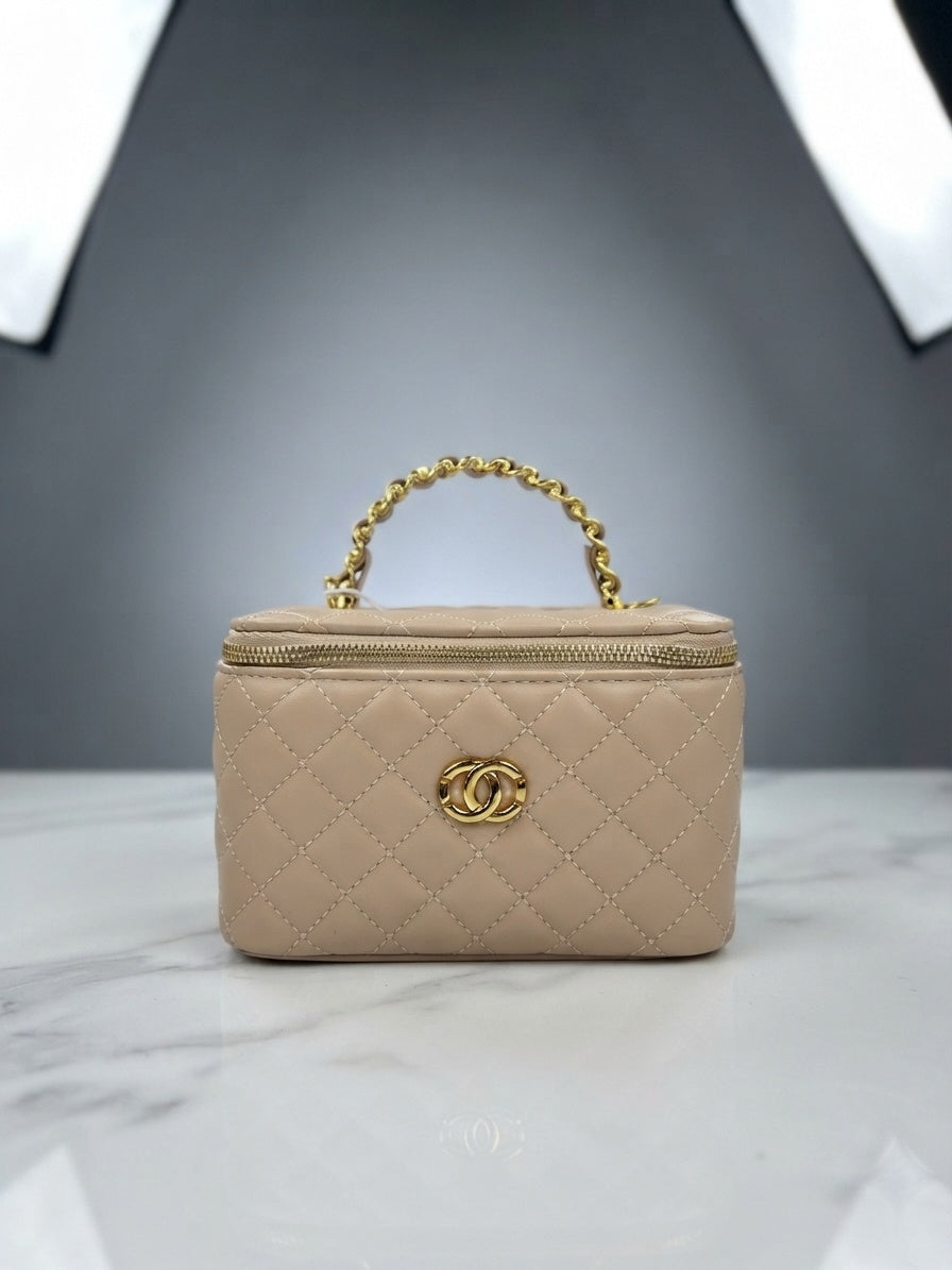 Beige quilted vanity cosmetic case with chain handle, top zip, and interlocking CC logo
