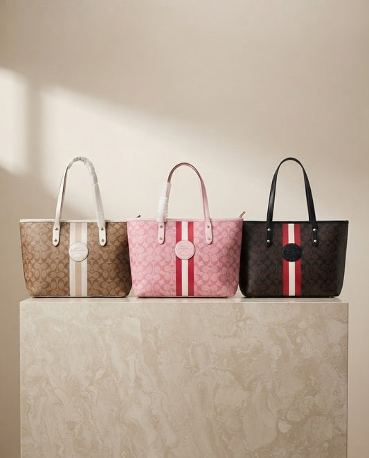 Three monogram structured tote bags: beige, pink, and black with red/white stripe