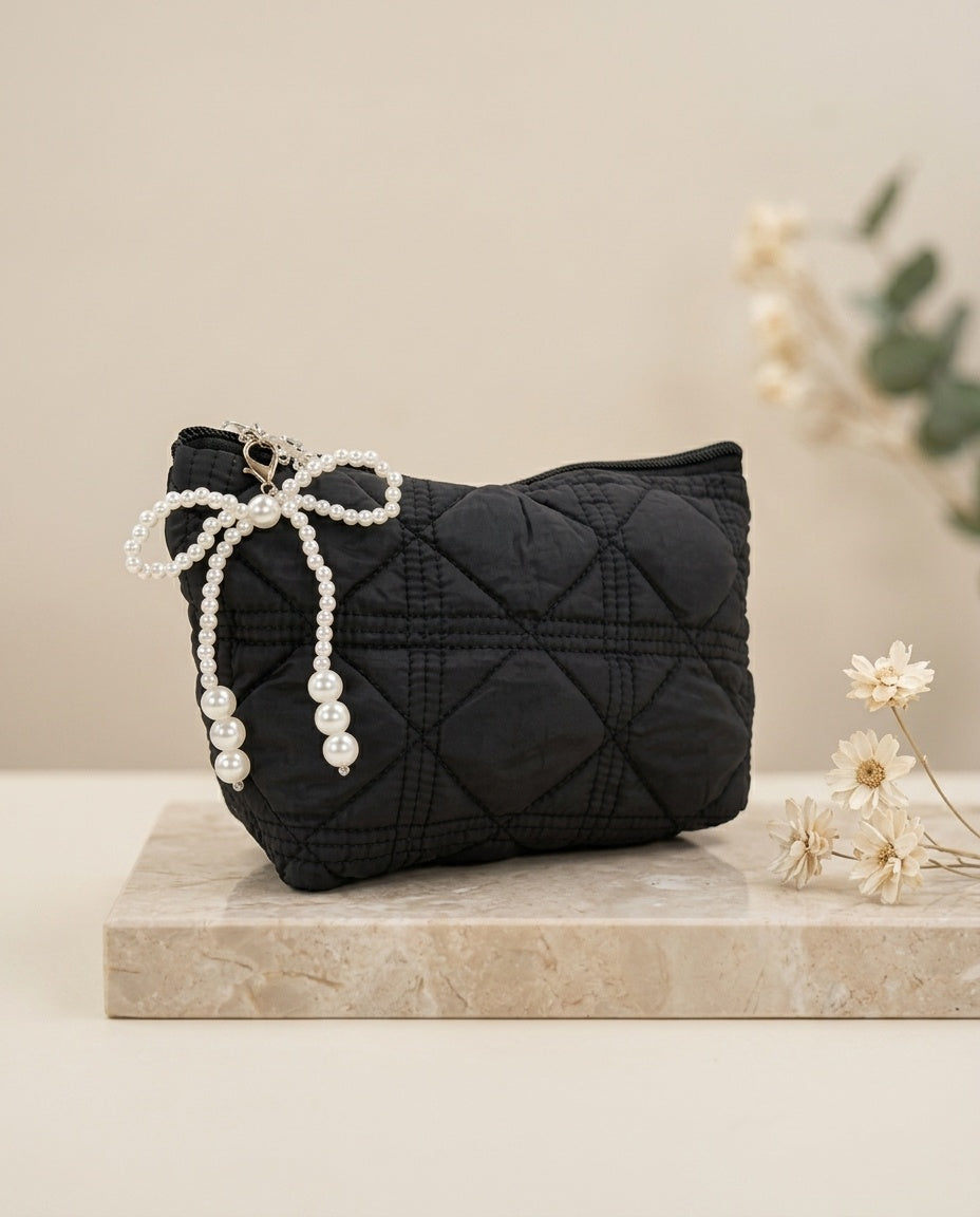 Black quilted cosmetic pouch with faux pearl bow charm and beaded tassel