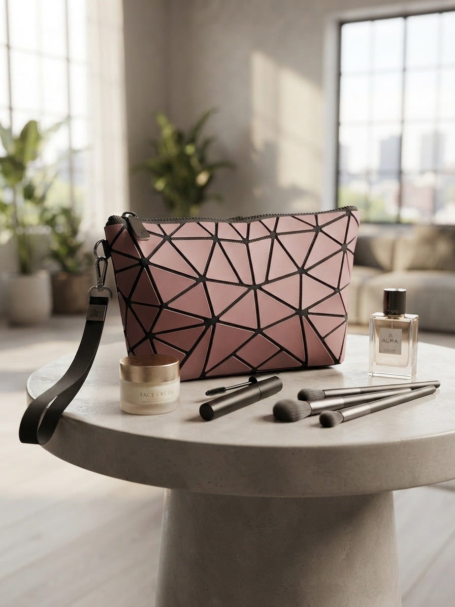 Geometric origami clutch wristlet bag in pink with black geometric pattern and crossbody strap