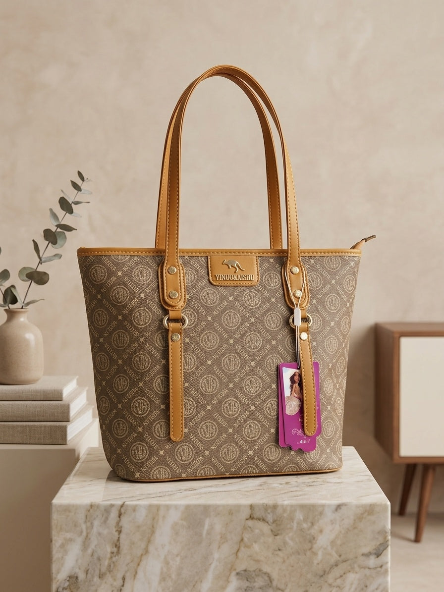 Monogram tote bag with light brown repeating pattern, tan leather handles, and purple charm