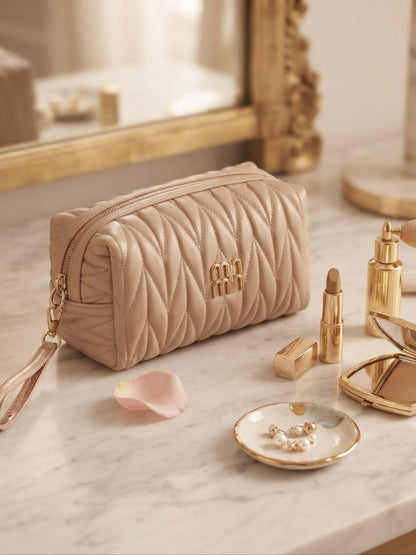 Beige quilted cosmetic pouch with wristlet strap and gold logo