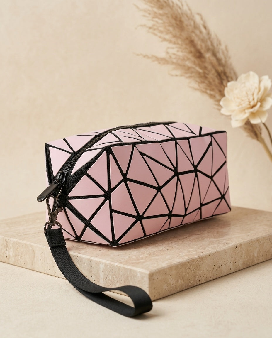 Pink geometric cosmetic pouch with wristlet strap, black zipper, faceted design