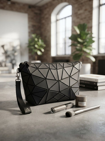 Geometric origami clutch wristlet bag in black with textured geometric pattern and wrist strap