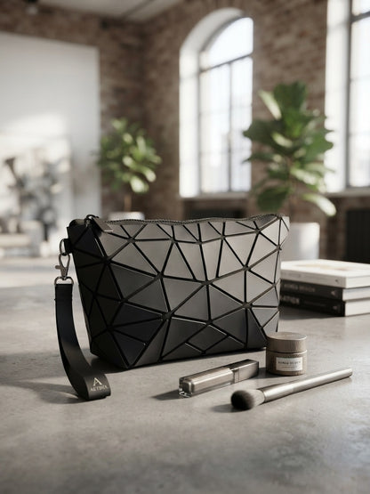 Geometric origami clutch wristlet bag in black with textured geometric pattern and wrist strap