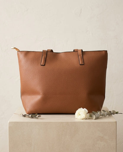 Pebbled faux leather pocket tote bag in brown with buckle strap handles and front pocket