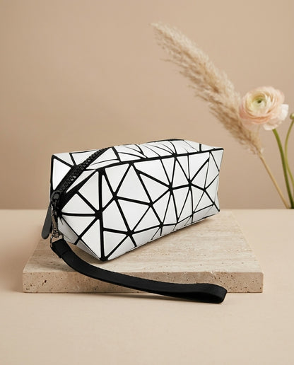 White geometric cosmetic pouch with black trim, zipper, and wristlet strap