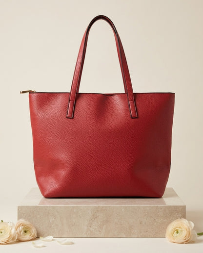 Pebbled faux leather pocket tote bag in red with buckle strap handles and front pocket