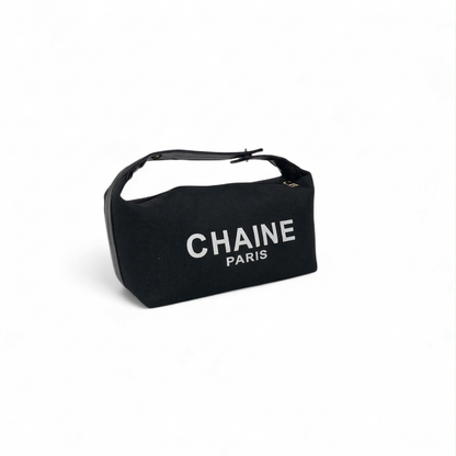 Black canvas cosmetic pouch with top handle strap and CHAINe PARIS logo