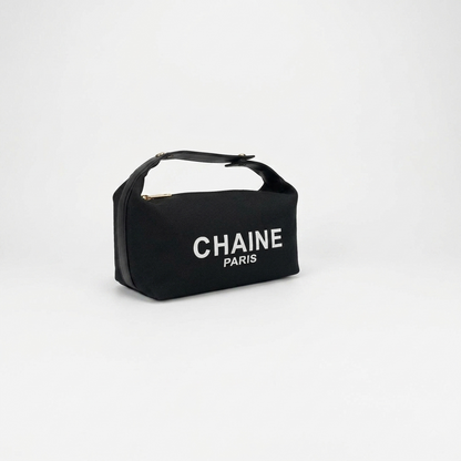 Black canvas cosmetic pouch with black top handle and CHAINe PARIS logo