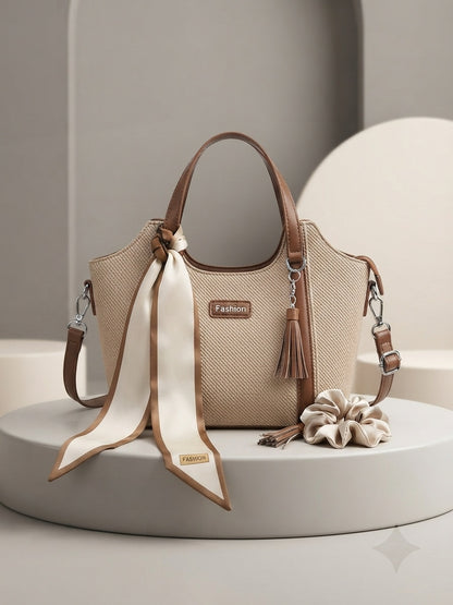Beige structured top-handle bag with scarf bow, tassel charm, and crossbody strap