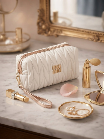 White quilted cosmetic pouch with wristlet strap and gold logo, gold zipper pull
