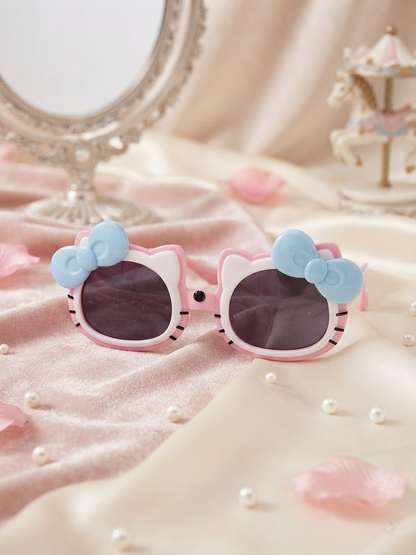 Kids cat-style sunglasses with dark lenses, pink frame, and light blue bow accents