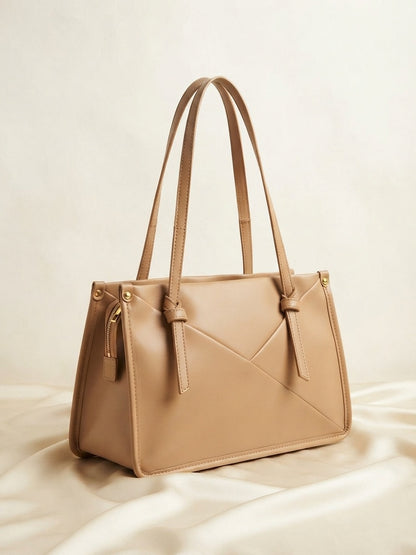 Knot-accent structured shoulder bag in light beige with top handles and diagonal seam