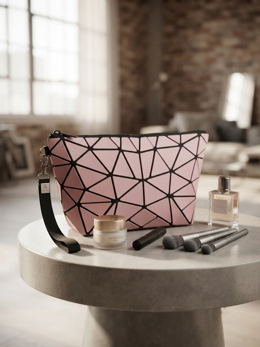Geometric origami clutch wristlet bag in blush pink with black geometric pattern and wrist strap