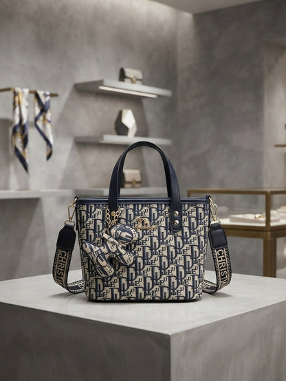 Structured monogram print tote bag with attached mini pouch charm; navy and black