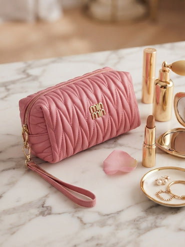 Pink quilted cosmetic pouch with wristlet strap and gold logo, gold zipper pull