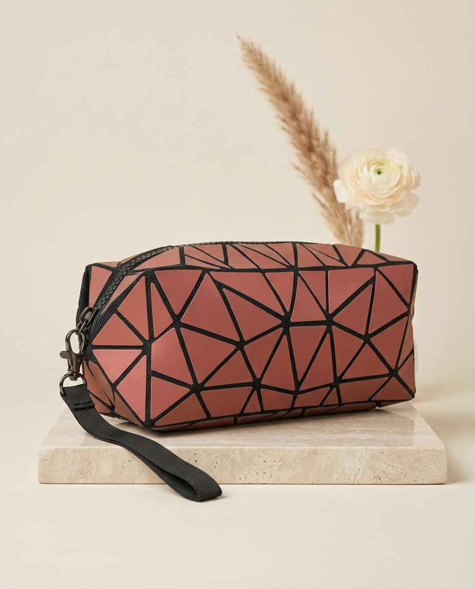 Pink geometric cosmetic pouch with wristlet strap and zipper, top view